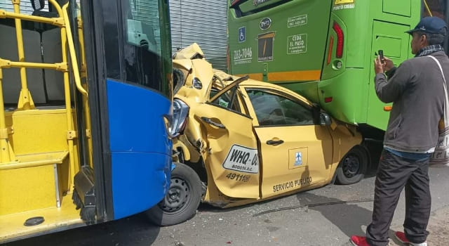 Taxi quedó destruido en medio de dos buses públicos
